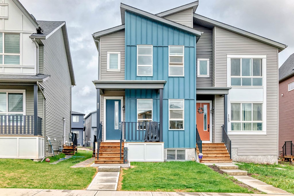 A blue and grey house with a white door and windows.