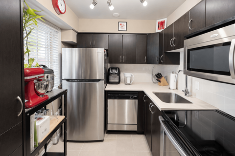 A modern kitchen with a stainless steel refrigerator, microwave, and dishwasher.