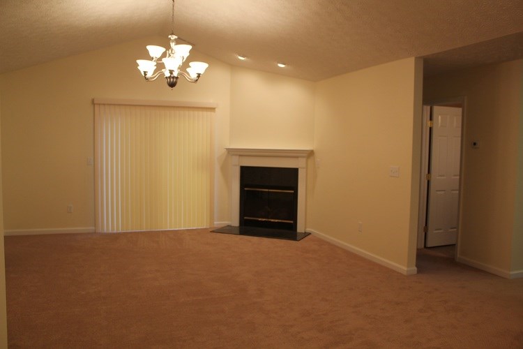 A living room with a fireplace and a chandelier.