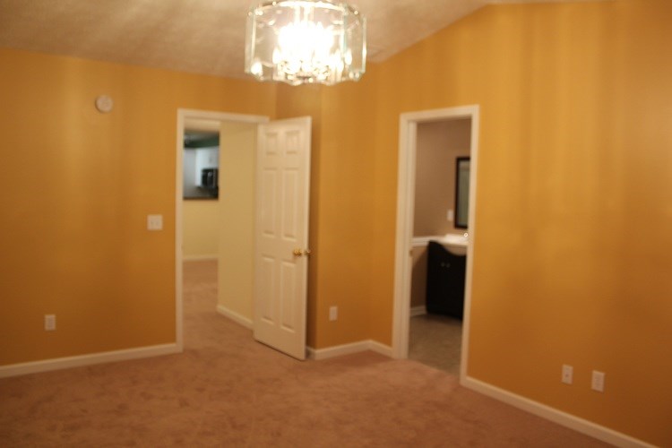 A room with a chandelier and two doors.