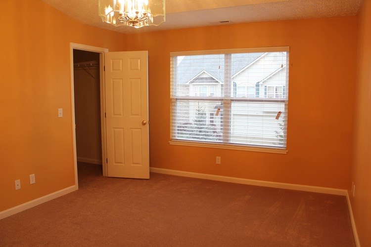 A room with orange walls and a white door.