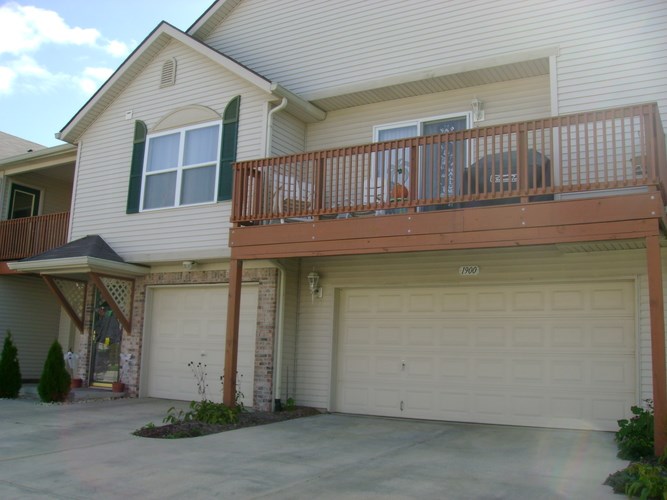 A house with a balcony and a garage door.