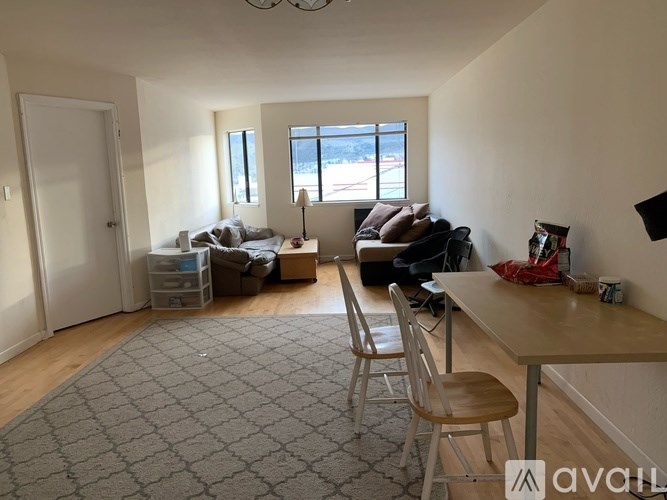 A living room with a couch, chair, and a dining table.