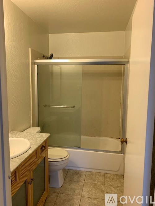 A bathroom with a toilet, sink, and shower.