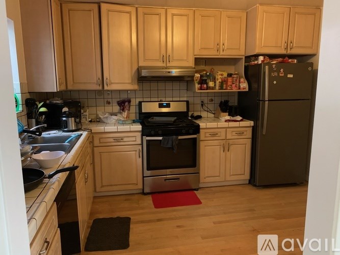 A kitchen with wooden cabinets and a black fridge.