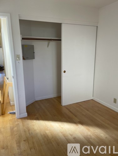 A room with a wooden floor and a white door.