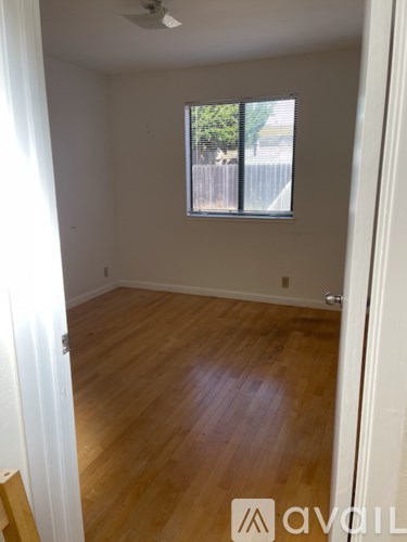 A room with wooden flooring and a window.