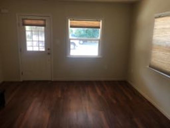 A room with a wooden floor and a window.