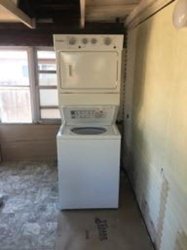 A white dryer and washer are stacked on top of each other.
