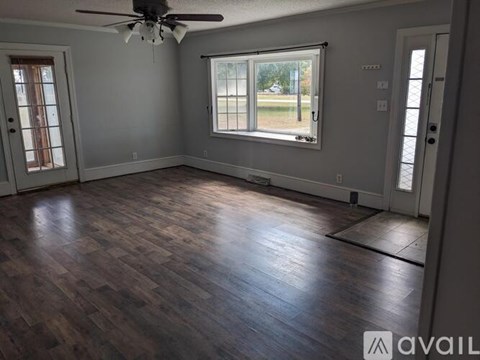 A room with wooden flooring and a ceiling fan.