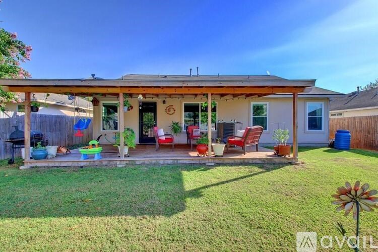 A house with a covered patio and lawn.