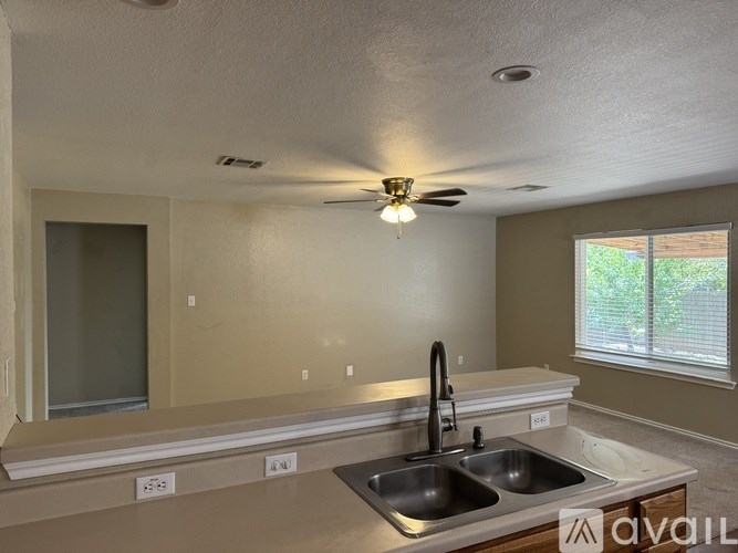 A bedroom with a bed, dresser, mirror, and a fan.
