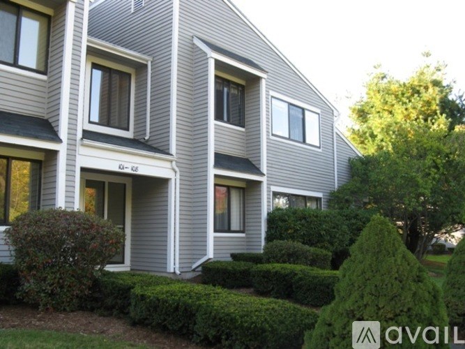 A grey house with a white trim and windows.