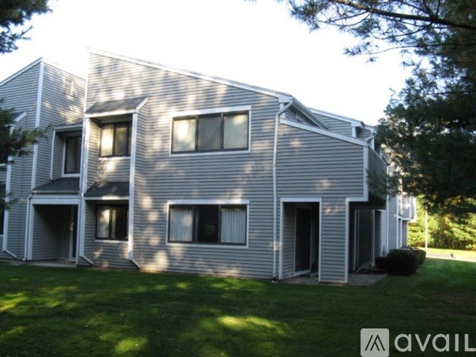 A house with a grey siding and white trim is available for rent.