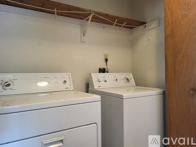 Two white washing machines in a small laundry room.