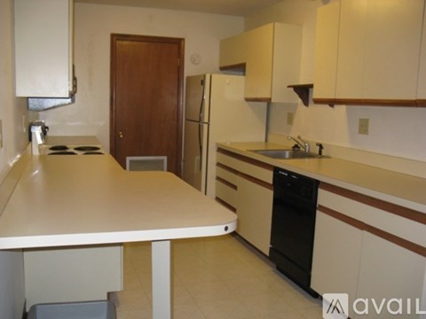 A kitchen with a white counter top and brown cabinets.