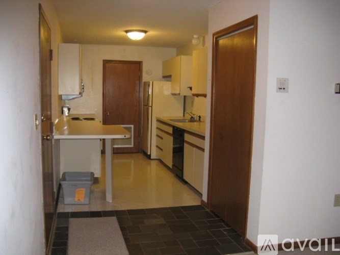 A kitchen with a table and a refrigerator.