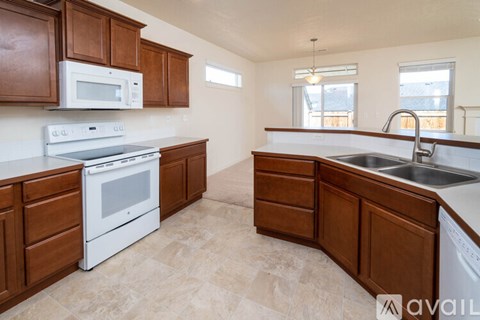 A kitchen with brown cabinets and white appliances.