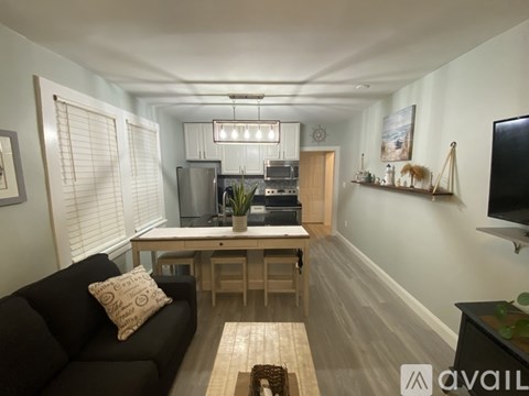 A living room with a black couch and a wooden coffee table.