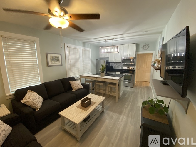 A living room with a black couch and a wooden coffee table.