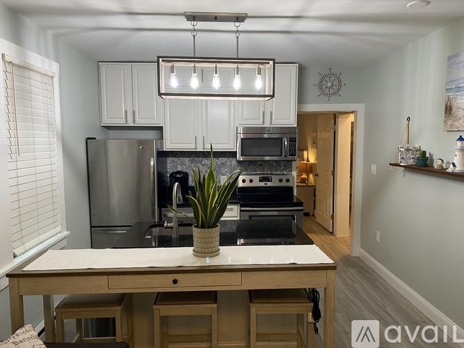 A kitchen with a wooden table and a plant on it.