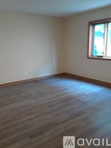 A room with wooden flooring and a window.