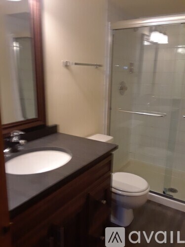 A bathroom with a sink, toilet and glass shower door.
