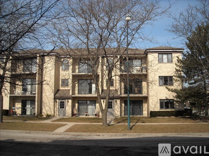 Apartment building with a tree in front of it.