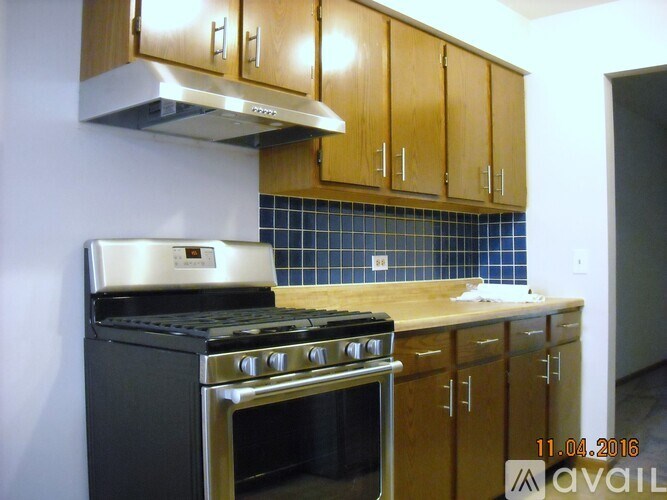 A kitchen with wooden cabinets and a black stove top oven.