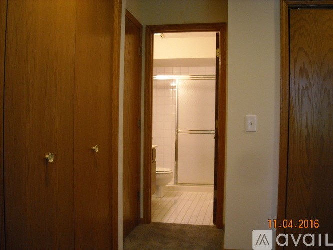 A wooden door with a handle and a lock is open.