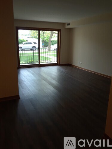 A room with wooden floors and a sliding glass door.