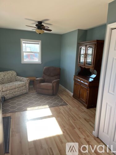 A living room with a couch, chair, and cabinet.