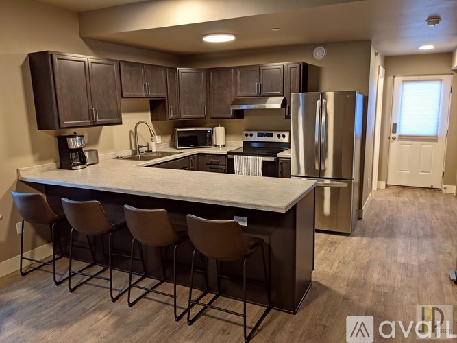 A kitchen with a bar and chairs.