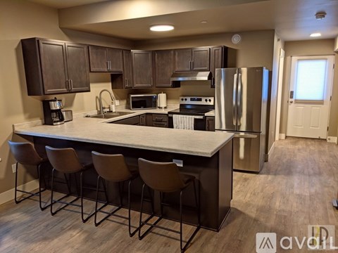 A kitchen with a bar and chairs.