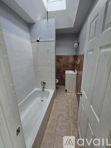 A bathroom with a bathtub, toilet, and sink.