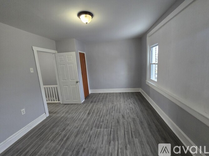 A room with a wooden floor and a white door.