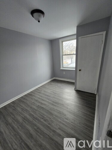 A room with grey flooring and a white door.