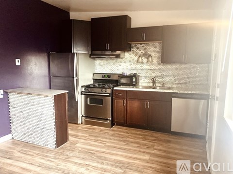 A kitchen with a refrigerator, oven, and microwave.