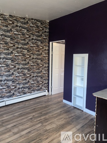 A room with a stone wall and wooden flooring.