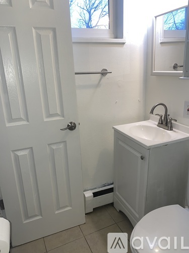 A white bathroom with a toilet, sink, and a door.