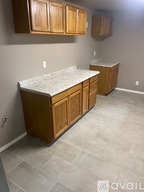 A kitchen with wooden cabinets and a marble countertop.