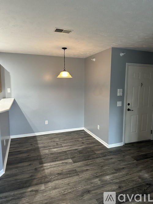 A room with a grey wall and a white door.