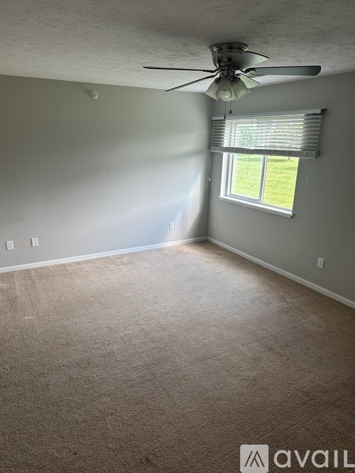 A room with a ceiling fan and a window.
