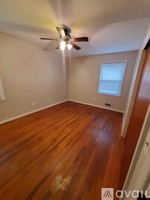 A room with wooden floors and a ceiling fan.