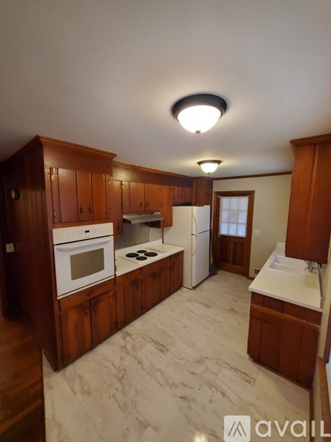 A kitchen with wooden cabinets and a white fridge.