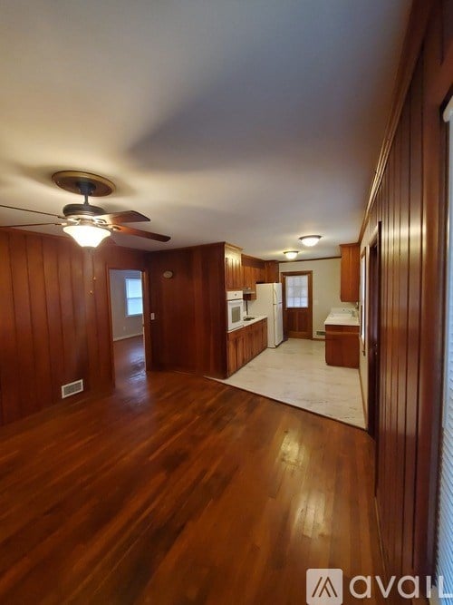 A room with wooden floors and a ceiling fan.