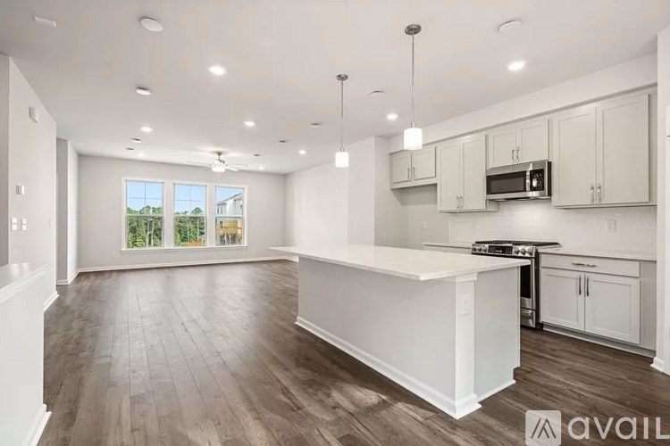 A spacious kitchen with white cabinets and a large island.