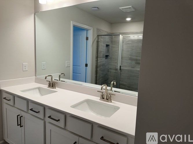 A bathroom with two sinks and a large mirror.