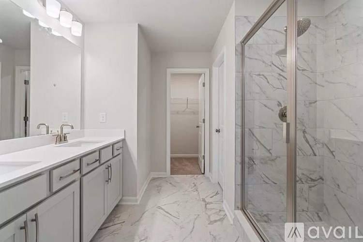 A bathroom with marble floors and a walk-in shower.