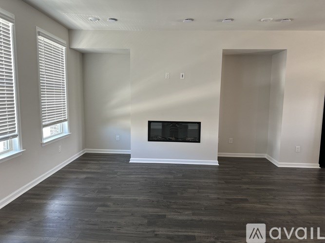 A spacious living room with a fireplace and hardwood floors.